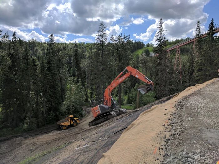 Excavator working on a steep hill for slope repair project