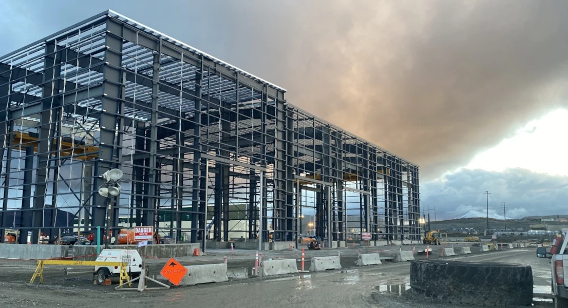 construction site, a large steel form building for a heavy equipment shop on a cloudy day