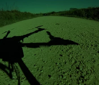 An artistic shot showing the shadow of the drone on a dirt road.