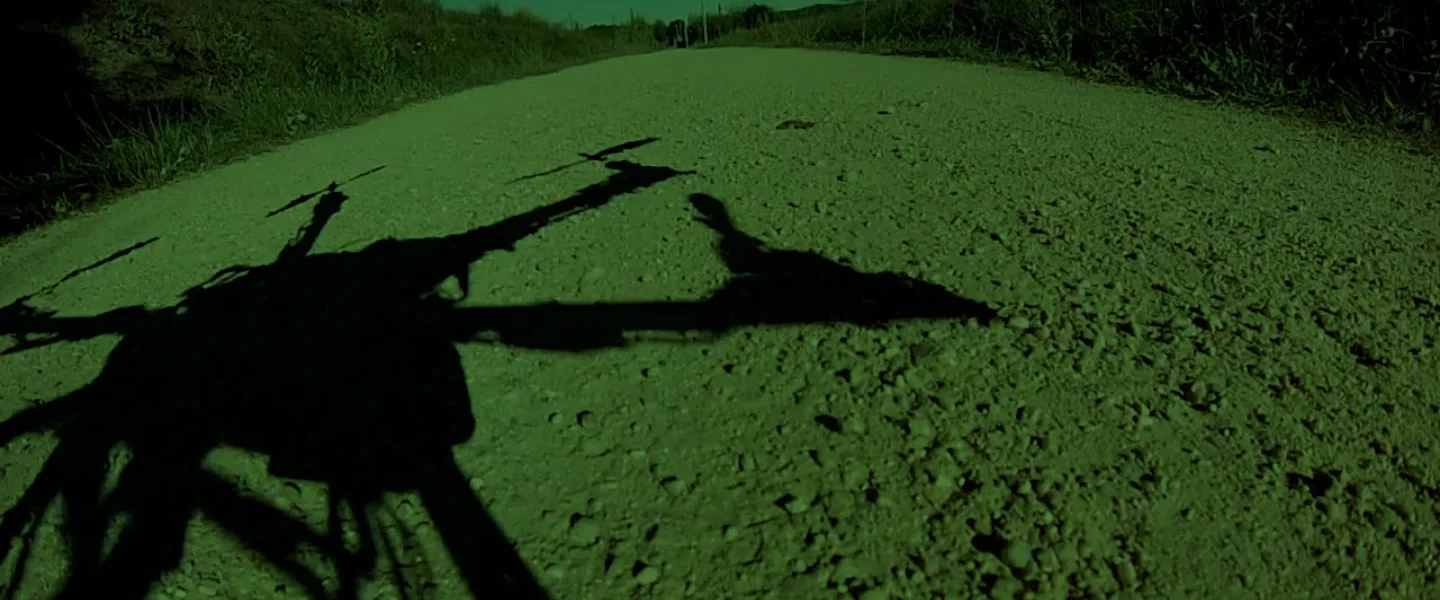 An artistic shot showing the shadow of the drone on a dirt road.