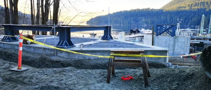 Construction site overlooking water, concrete foundation poured waiting for next phase