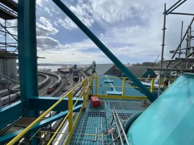 view of rail yard on a sunny day from high above on a steel structure