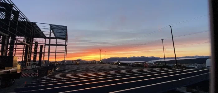 artistic shot of red chris mine heavy equipment shop under construction at sunset